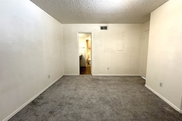 carpeted empty room featuring visible vents, baseboards, and a textured ceiling