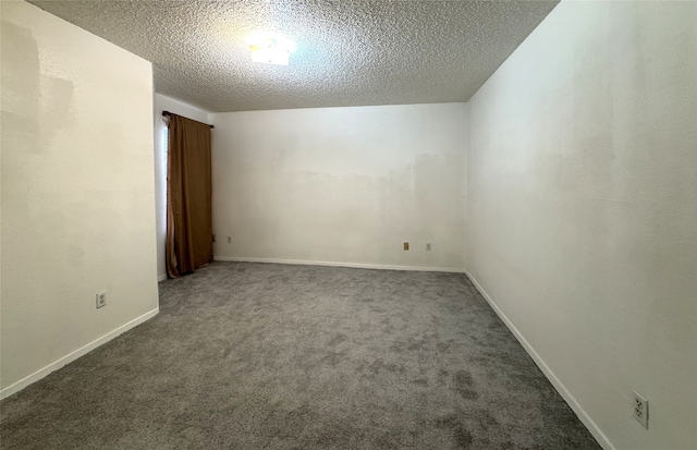 carpeted empty room with a textured ceiling and baseboards