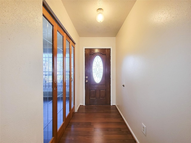 doorway with baseboards and wood finished floors