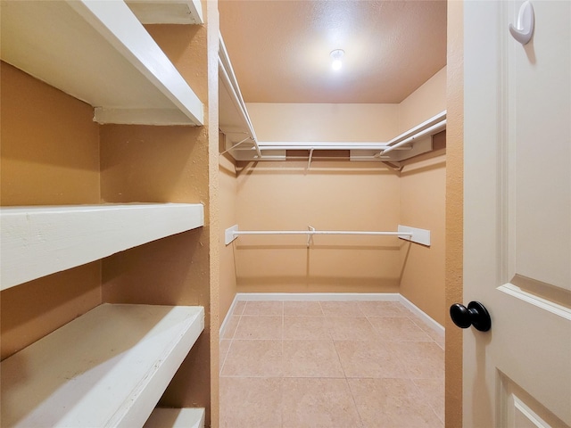 spacious closet featuring tile patterned flooring