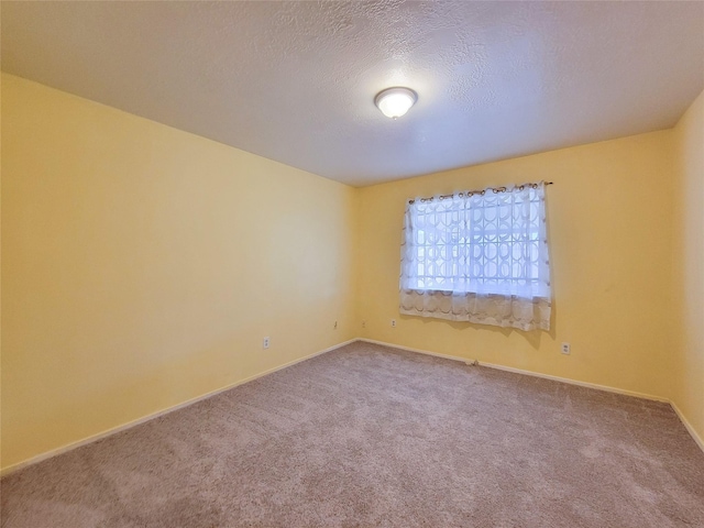 carpeted empty room with baseboards and a textured ceiling