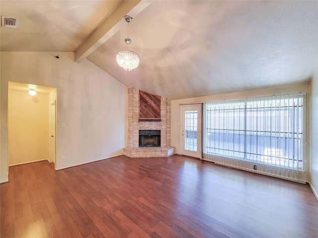 unfurnished living room with visible vents, dark wood-style flooring, an inviting chandelier, a fireplace, and vaulted ceiling with beams