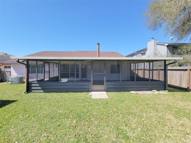 rear view of house featuring central AC unit, a lawn, fence, and a sunroom