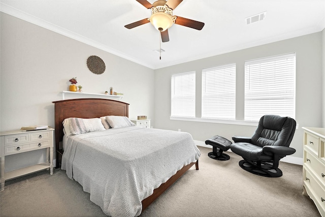 carpeted bedroom featuring ceiling fan, baseboards, visible vents, and ornamental molding