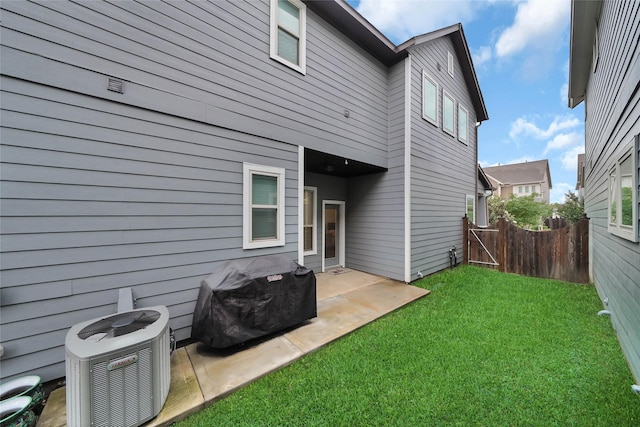 back of property featuring a patio, a yard, fence, and central AC