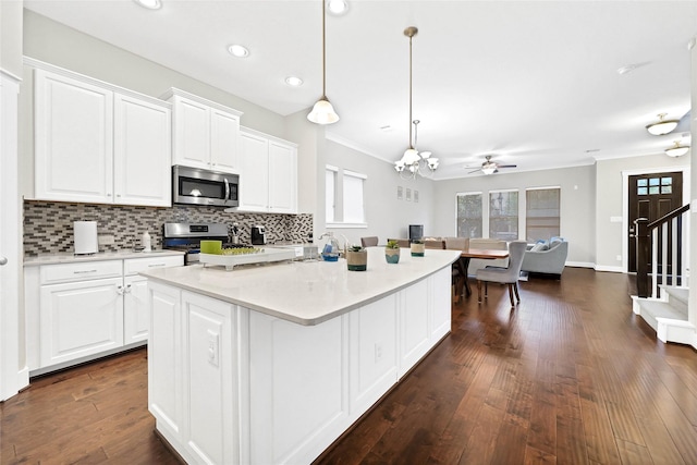 kitchen with decorative backsplash, appliances with stainless steel finishes, dark wood-style flooring, and white cabinetry