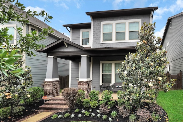 view of front of home featuring brick siding and covered porch