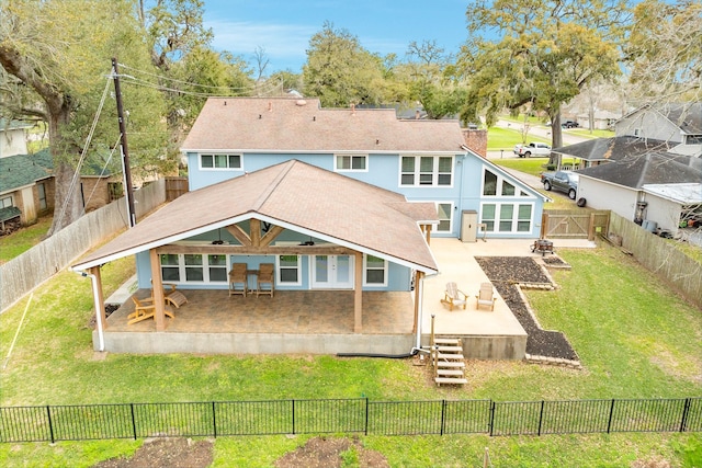 back of house with a gate, a yard, a fenced backyard, stucco siding, and a patio area