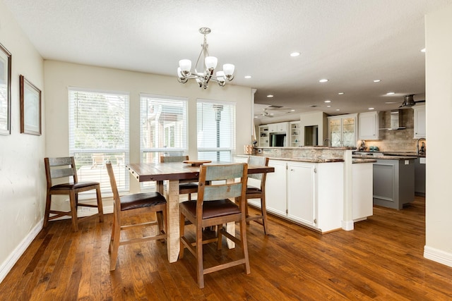 dining space featuring dark wood finished floors, recessed lighting, baseboards, and a chandelier