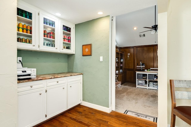 kitchen with visible vents, a ceiling fan, dark wood-style floors, white cabinets, and glass insert cabinets