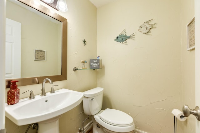 half bathroom featuring toilet and a sink