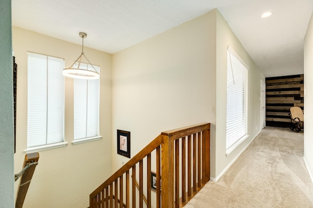 corridor featuring a wealth of natural light, an upstairs landing, recessed lighting, carpet flooring, and baseboards