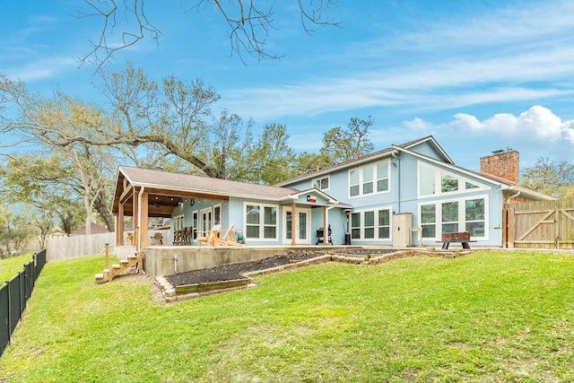 rear view of property with a patio, a fenced backyard, a lawn, and a chimney