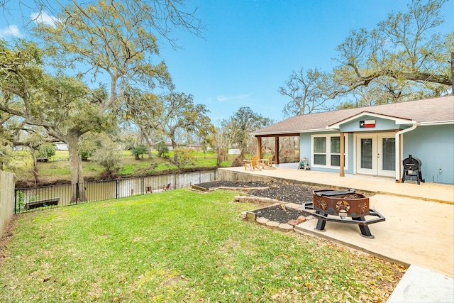 view of yard with french doors, an outdoor fire pit, a patio, and fence