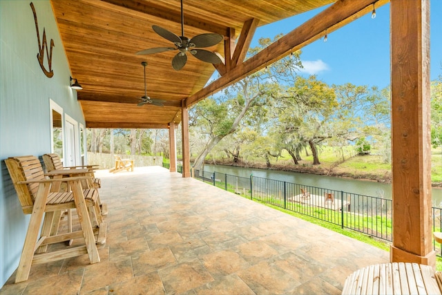 view of patio / terrace featuring fence, a water view, and ceiling fan