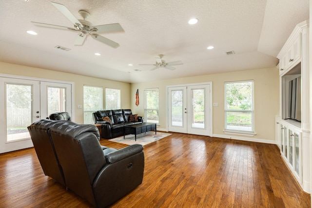 living area with visible vents, baseboards, recessed lighting, hardwood / wood-style flooring, and french doors