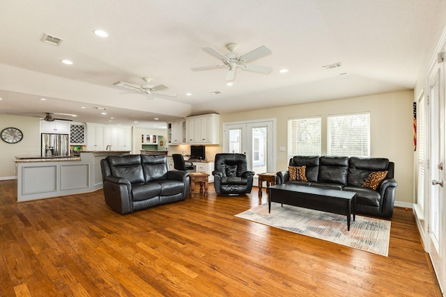 living area with visible vents, recessed lighting, and wood finished floors