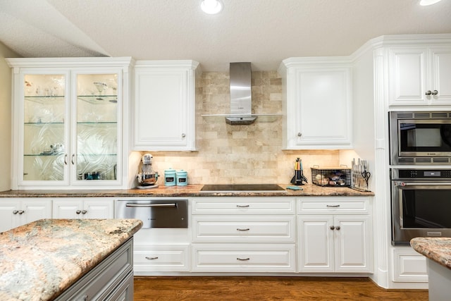 kitchen featuring tasteful backsplash, wall chimney range hood, stainless steel appliances, white cabinetry, and a warming drawer