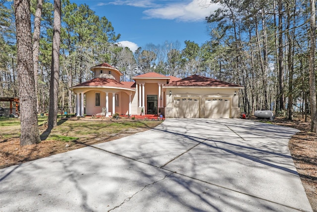 mediterranean / spanish home featuring a garage, driveway, and stucco siding