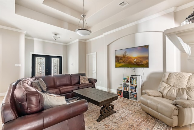 living room featuring visible vents, a raised ceiling, baseboards, and ornamental molding