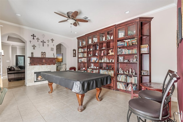 21971 Blazing Trl, New Caney, TX 77357 - playroom featuring a lit fireplace, arched walkways, light tile patterned floors, and a ceiling fan