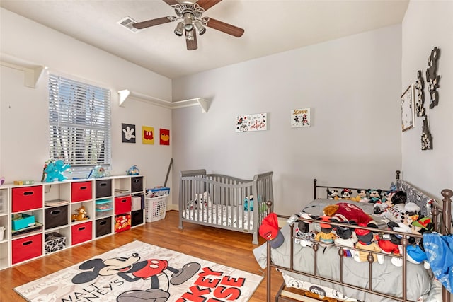 bedroom with visible vents, wood finished floors, and a ceiling fan