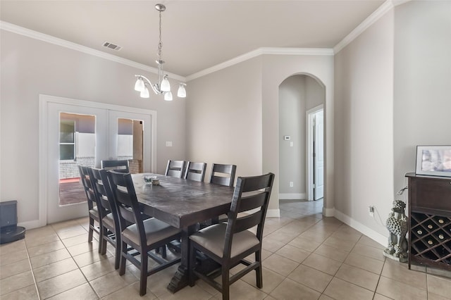 21971 Blazing Trl, New Caney, TX 77357 - dining space with visible vents, baseboards, ornamental molding, arched walkways, and light tile patterned floors