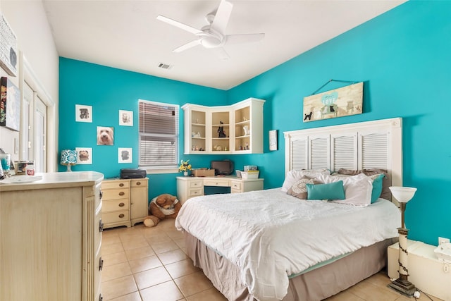 bedroom with light tile patterned floors, visible vents, and a ceiling fan