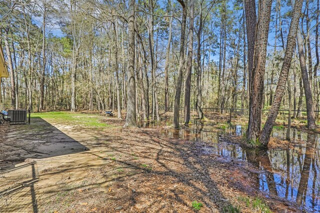 view of yard featuring a forest view and cooling unit