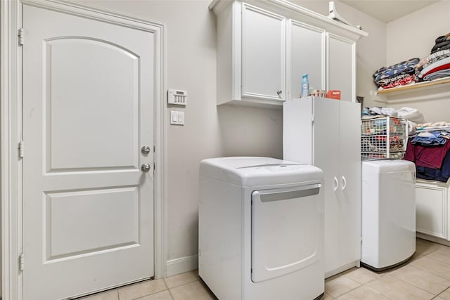 21971 Blazing Trl, New Caney, TX 77357 - clothes washing area featuring light tile patterned flooring, cabinet space, and independent washer and dryer