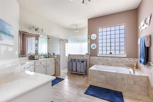 bathroom featuring vanity, a bath, tile patterned flooring, and walk in shower