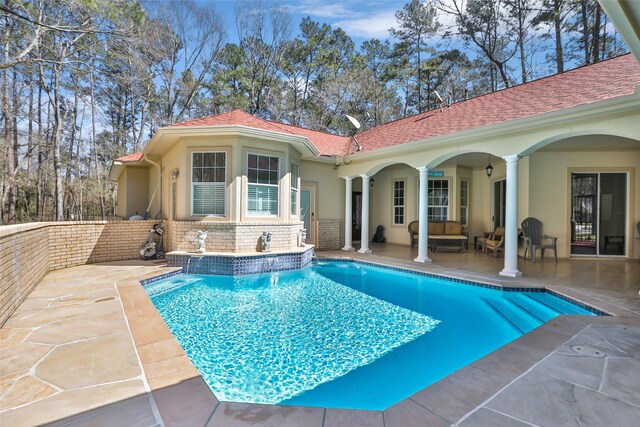 outdoor pool with an outdoor living space and a patio area