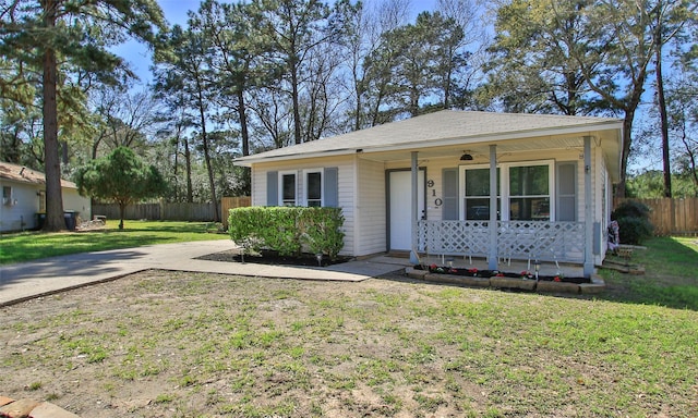 view of front facade featuring a porch, a front yard, and fence