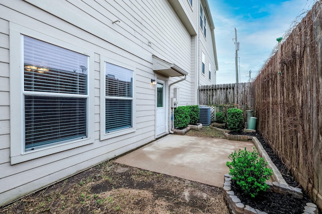 view of patio with central AC unit and fence