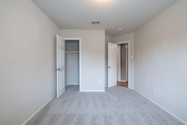 unfurnished bedroom featuring visible vents, baseboards, carpet, and a closet