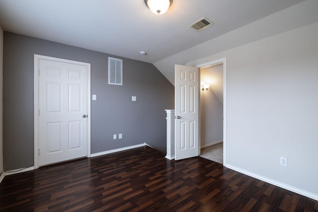 unfurnished room featuring dark wood-style floors, visible vents, and baseboards