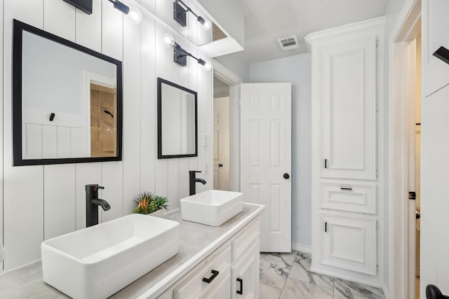 bathroom with double vanity, visible vents, marble finish floor, and a sink