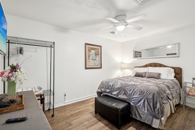 bedroom featuring visible vents, wood finished floors, baseboards, and ceiling fan