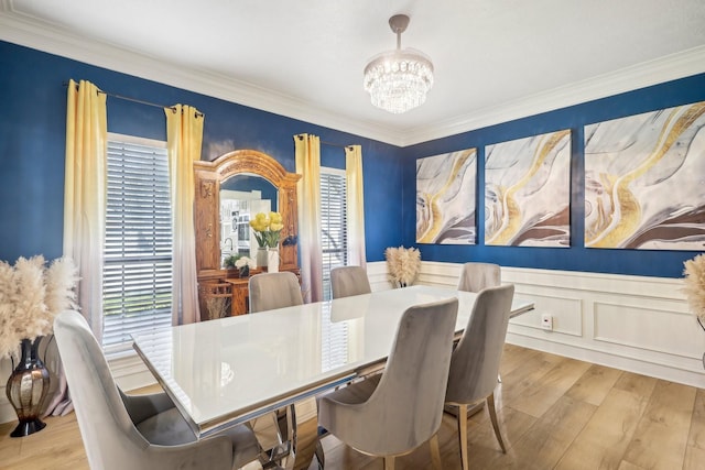 dining room with a chandelier, ornamental molding, and wood finished floors