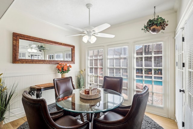 dining area featuring light wood finished floors, plenty of natural light, and ornamental molding