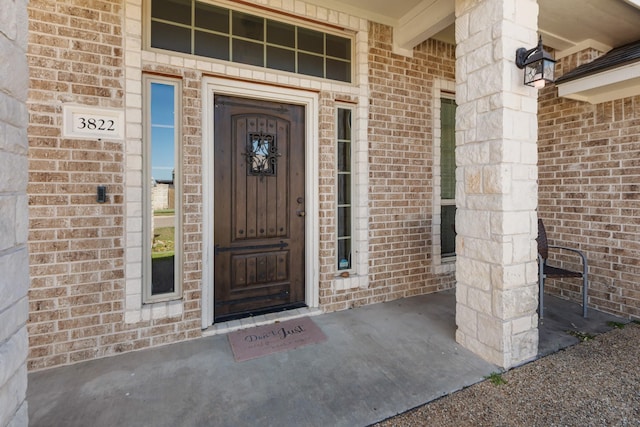 doorway to property featuring brick siding