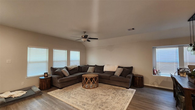 living room featuring vaulted ceiling, plenty of natural light, dark wood-style floors, and visible vents