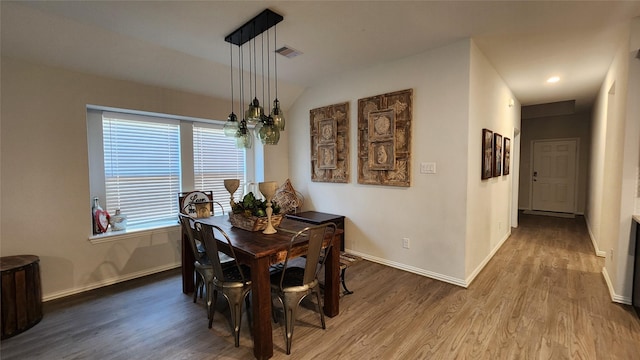 dining space with visible vents, baseboards, and wood finished floors