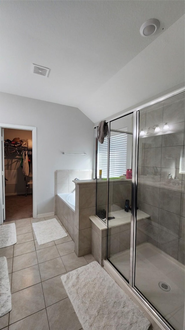 bathroom with tile patterned flooring, visible vents, vaulted ceiling, a stall shower, and a bath