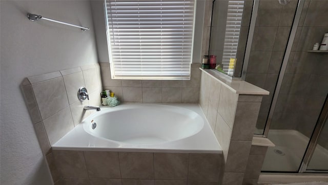 bathroom with a stall shower and a garden tub