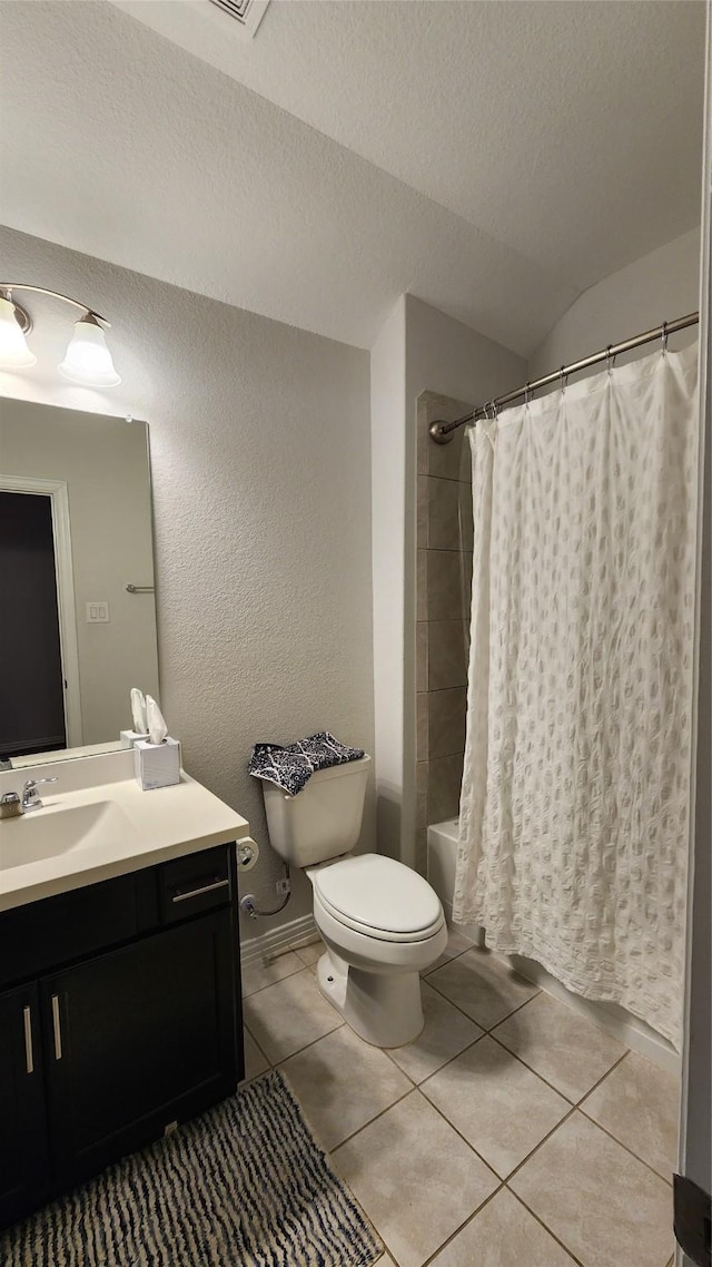 bathroom with tile patterned flooring, shower / bath combo with shower curtain, toilet, vanity, and a textured ceiling