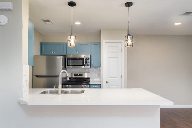 kitchen featuring visible vents, backsplash, blue cabinetry, stainless steel appliances, and a sink