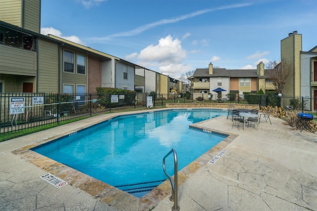 pool with a patio and fence