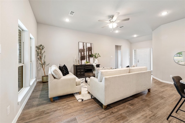 living area featuring visible vents, baseboards, and wood finished floors