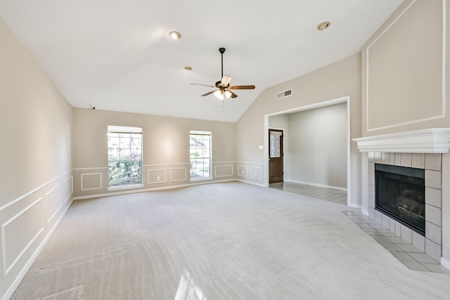 unfurnished living room featuring visible vents, ceiling fan, a tiled fireplace, light colored carpet, and a decorative wall